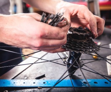 Image of a bicycle mechanic working on a drive train