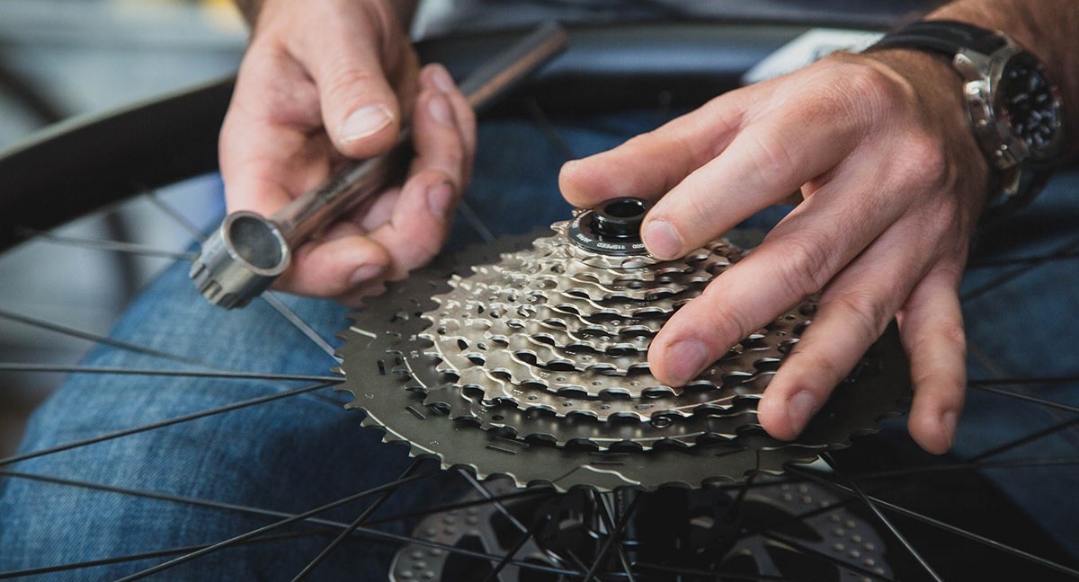 A bike mechanic installs a cassette onto a wheel